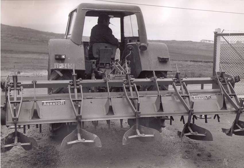 Agricultor trabajando en el campo con un rotovator de Agrator